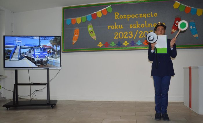 Uczeń przebrany za maszynistę zapowiada wjazd pociągu ze stacji wakacje.