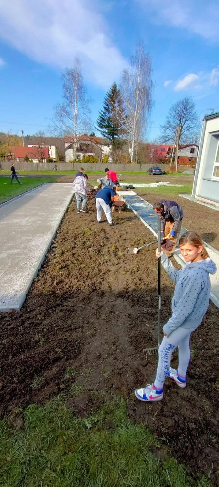 Uczniowie pracują w szkolnym ogrodzie.