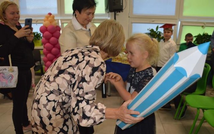 Pani dyrektor pasuje na ucznia uczennicę Ilonkę. 