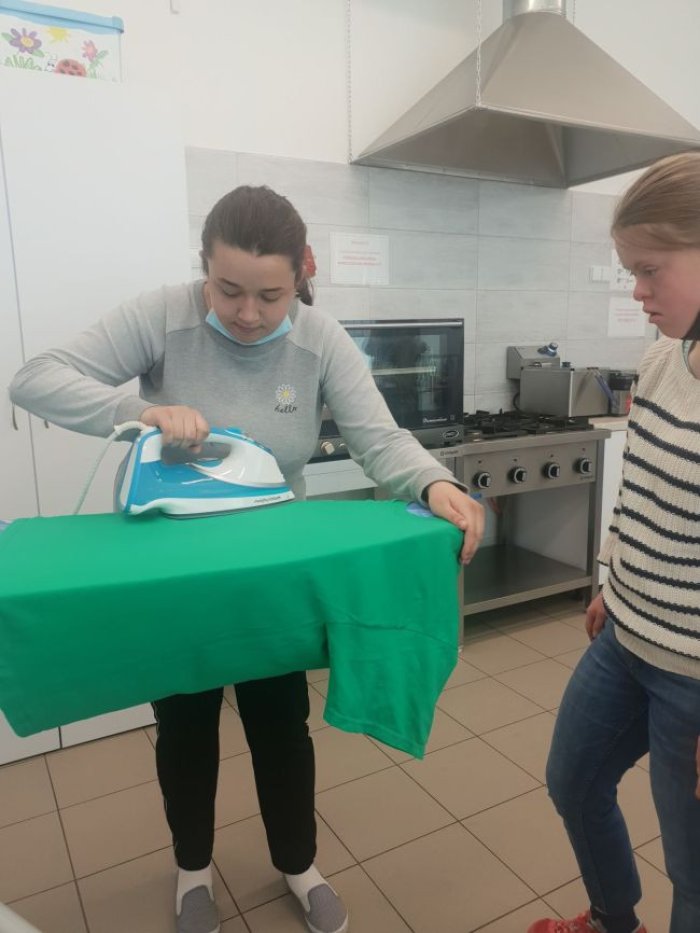 Uczennica prasuje odzież wierzchnią.