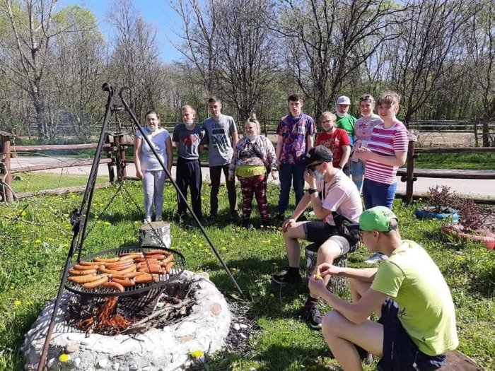 Uczniowie śpiewają przy ognisku. 