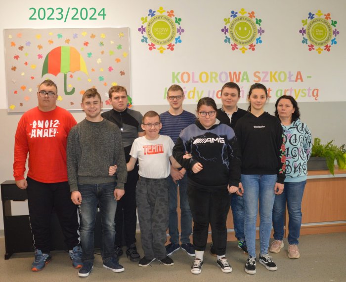 Uczniowie klasy przysposabiającej do pracy pozują do zdjęcia klasowego wraz z wychowawczynią.