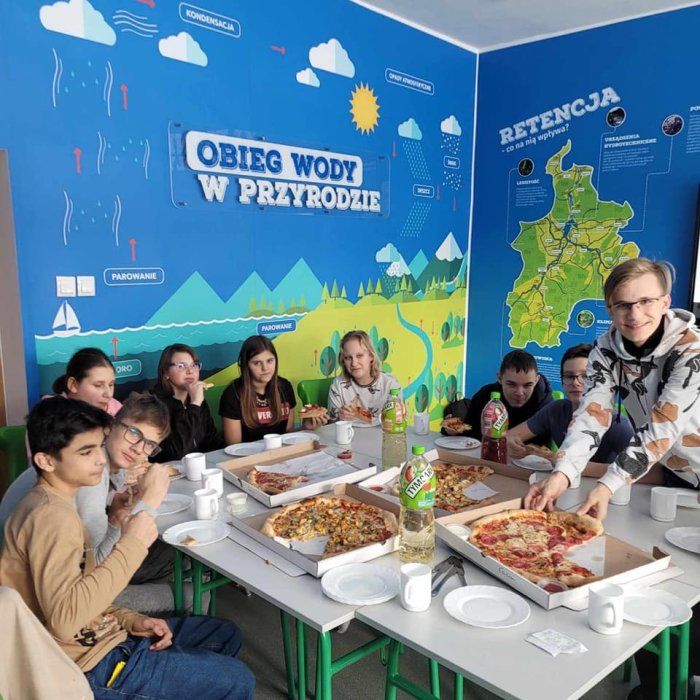 Uczniowie degustują pizzę.