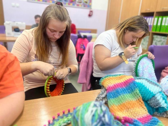 Uczennice pracują z obręczami dziewiarskimi.