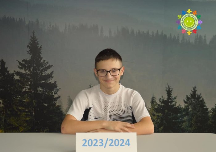 Uczeń pozuje do zdjęcia.