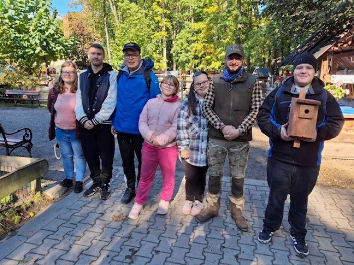 Uczniowie klas przysposabiających do pracy pozują do zdjęcia z kierownikiem mini zoo w Żywcu.