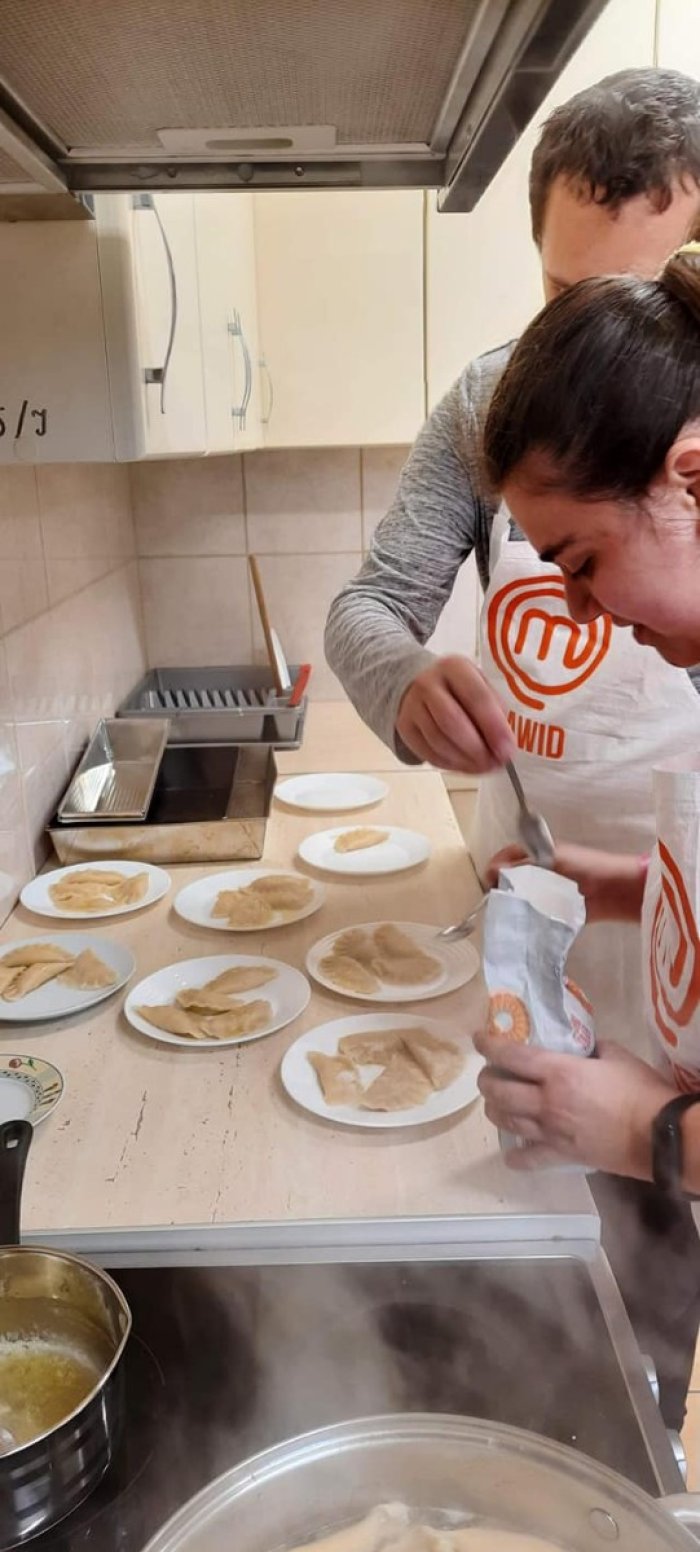 Uczniowie serwują wykonane pierogi. 