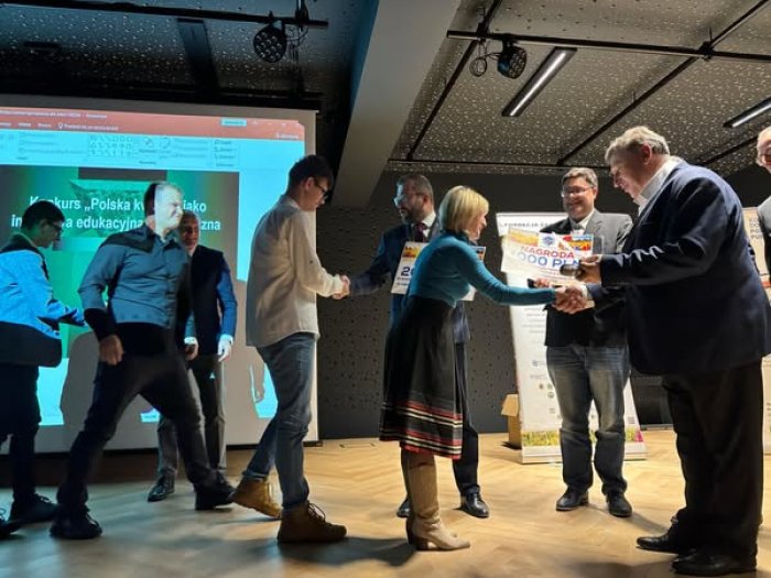 Pani dyrektor wraz z uczniami odbiera główną nagrodę w konkursie Polska kwitnie. 