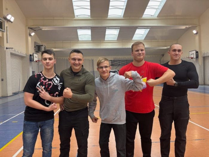 Uczniowie pozują do zdjęcia z belfrem na pełnej petardzie.