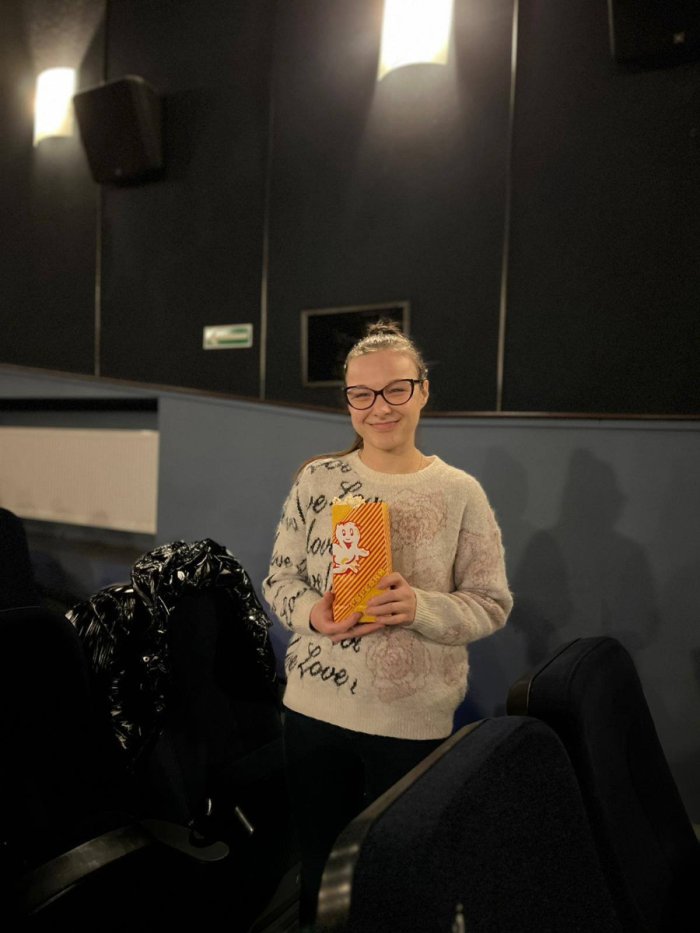 Uczennica w kinie z popcornem.