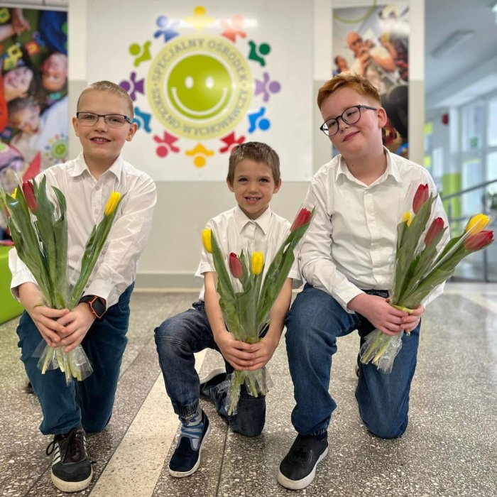 Chłopcy trzymają w rękach tulipany dla pań.