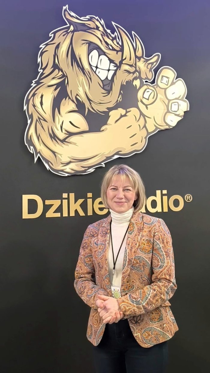 Pani dyrektor ośrodka Magdalena Worek  pozuje na tle baneru Dzikiego radia.