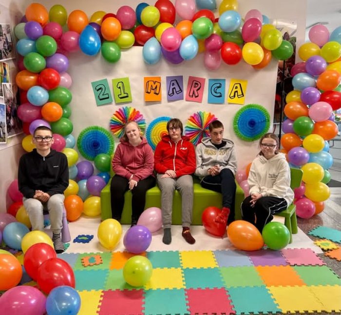 Uczniowie pozują w foto budce z okazji dnia kolorowej skarpetki.
