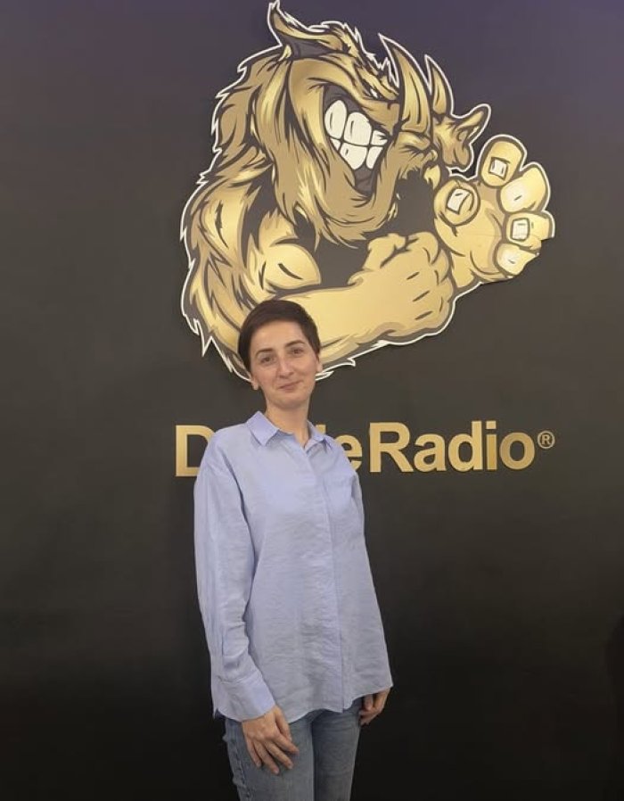 Pani psycholog Marta pozuje na tle foto ścianki w dzikim radiu.