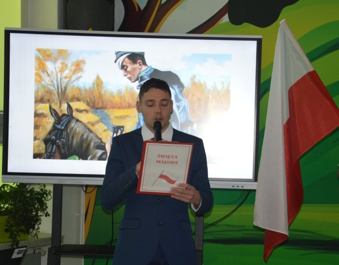 Uczeń z powagą czyta wiersz patriotyczny.