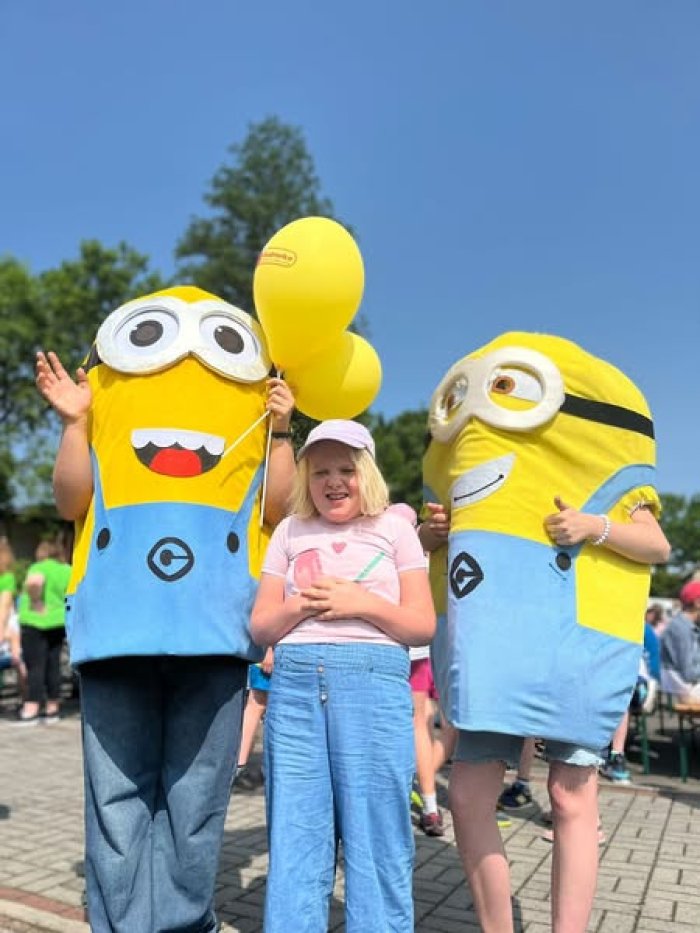Uczennica pozuje do zdjęcia z minionkami.
