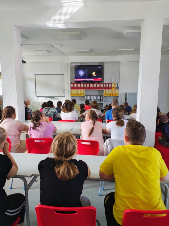 Uczniowie oglądają start rakiety w kosmos.