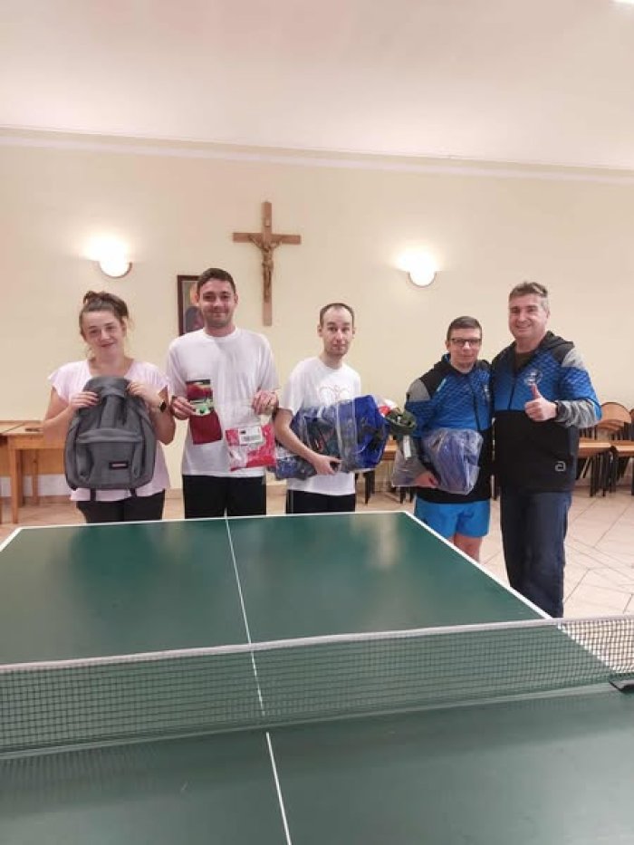 Uczestnicy turnieju tenisa stołowego prezentują nagrody.