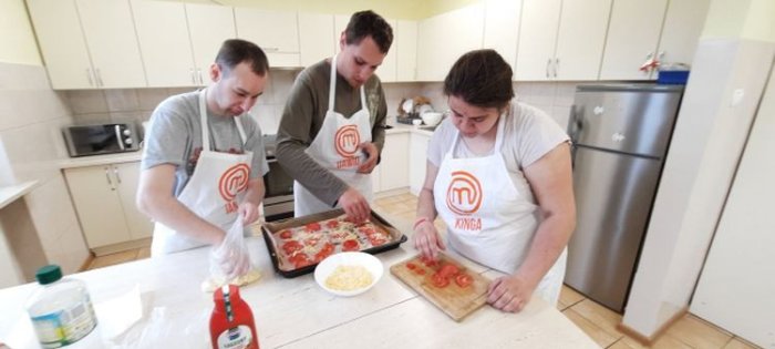Uczniowie komponują składniki na pizzę.