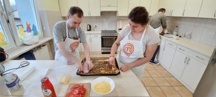 Uczniowie przygotowują ciasto na pizzę.