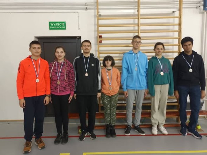 Uczniowie naszej szkoły prezentują zdobyte przez siebie medale na zawodach.