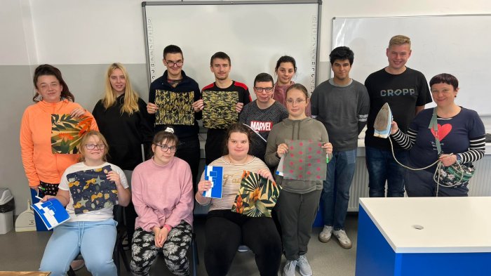 Uczestnicy warsztatów prezentują woskowane ściereczki .