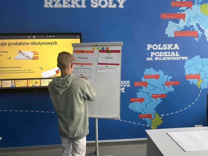 Uczeń pracuje przy tablicy multimedialnej.