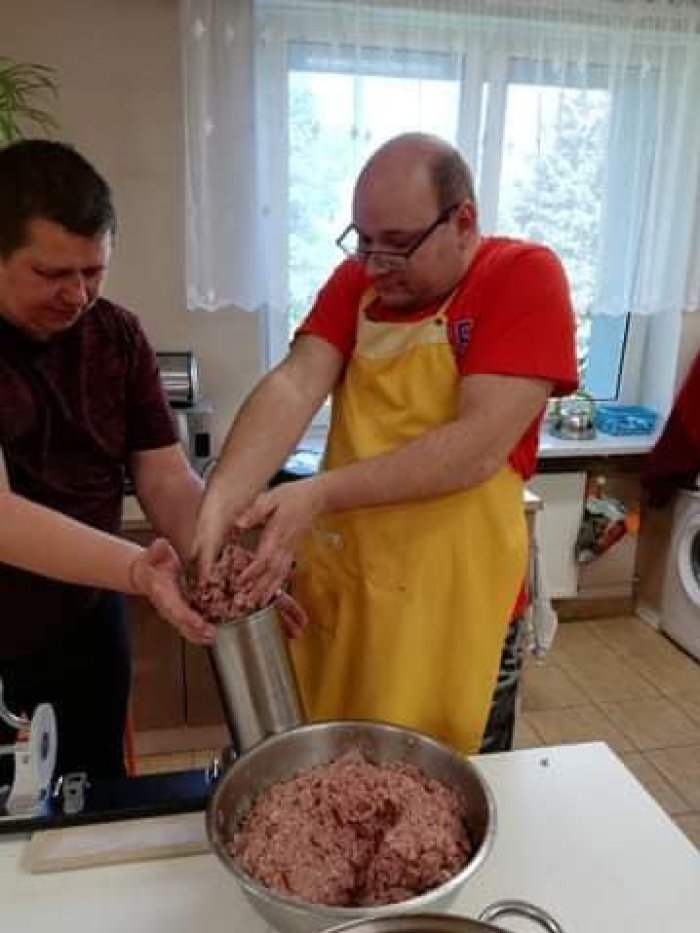 Uczniowie mielą mięso na kiełbasę.
