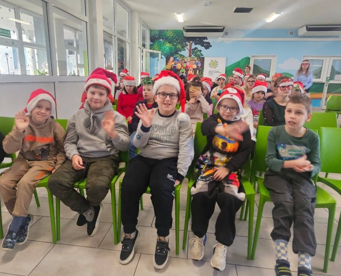 Uczniowie w czapkach mikołajkowych.