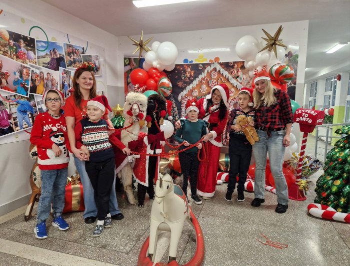 Uczniowie pozują do zdjęcia z alpakami.