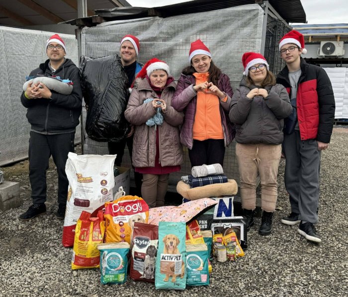 Uczniowie w schronisku dla zwierząt przekazują zebrane dary.
