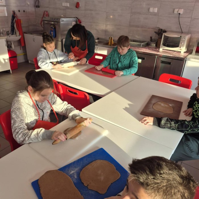 Uczniowie wałkują ciasto.