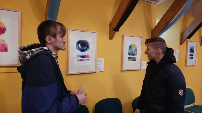 Uczniowie oglądają wystawę malarską.