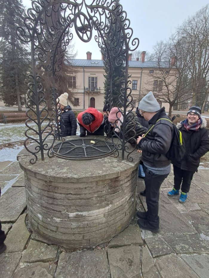 Uczniowie przy zabytkowej studni.