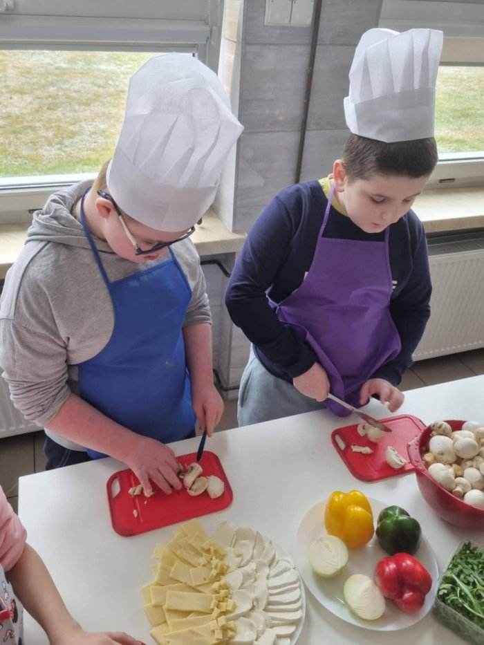 Uczniowie kroją pieczarki.