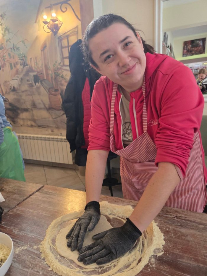 Uczennica wyrabia ciasto na pizzę.