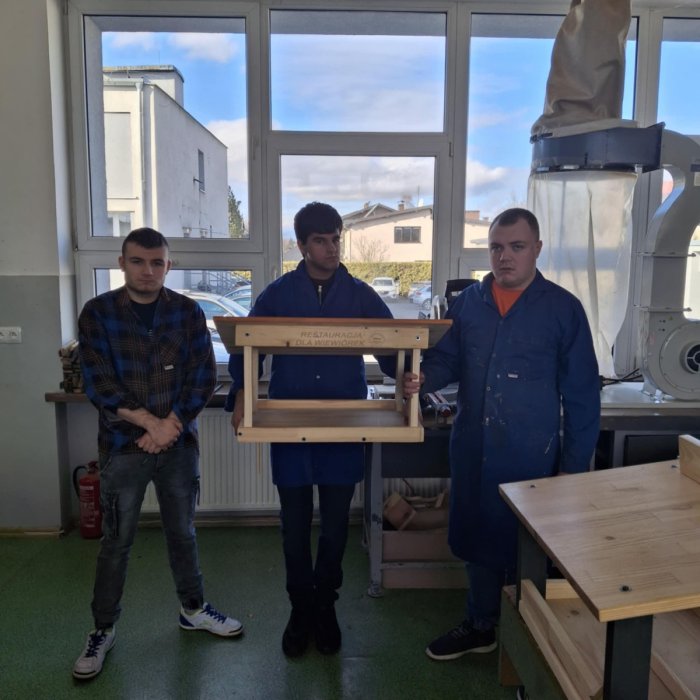 Uczniowie prezentują wykonaną na zajęciach restaurację dla wiewiórek.