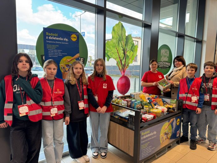 Wolontariusze prezentują zebrane dary żywnościowe. 