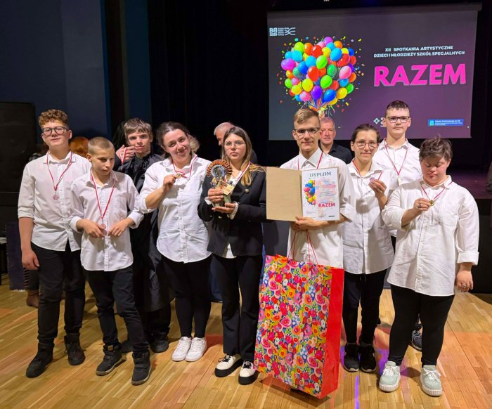 Uczniowie prezentują zdobytą nagrodę i dyplom podczas przeglądu teatralnego.