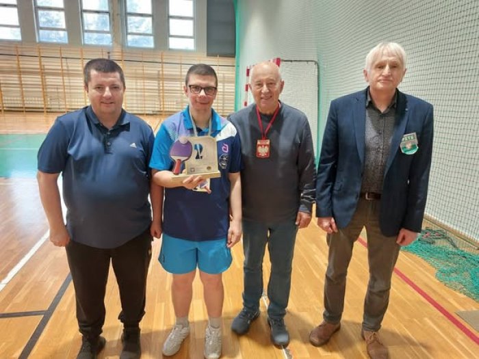 Uczeń naszej szkoły wraz z organizatorami turnieju sportowego.