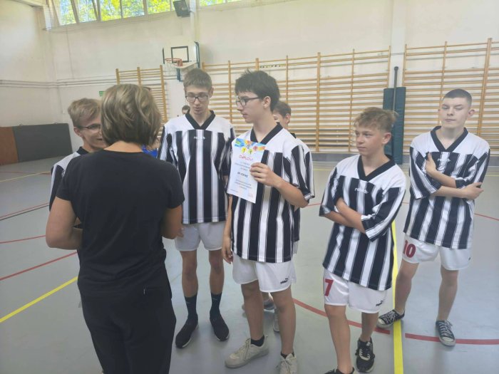 Szkolna drużyna sportowa odbiera dyplom.