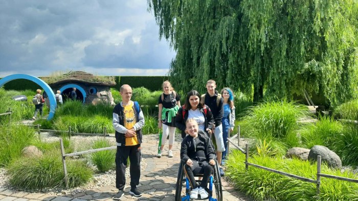 Uczniowie spacerują wśród roślinności ogrodów.
