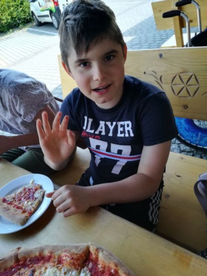 Uczeń degustuje pizzę.