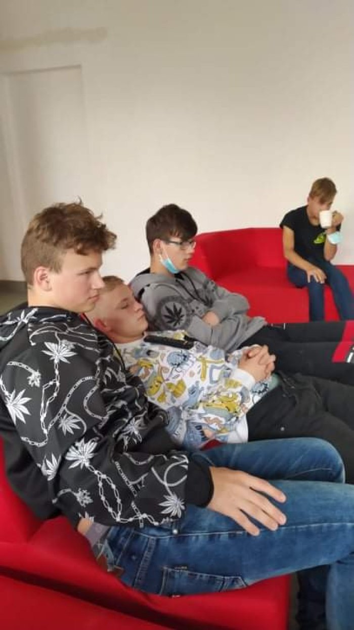 uczniowie odpoczywają na kanapie w sali telewizyjnej
