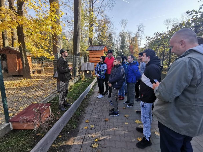 uczniowie i wychowawcy oraz dyrektor mini zoo podczas wspólnej pogawędki