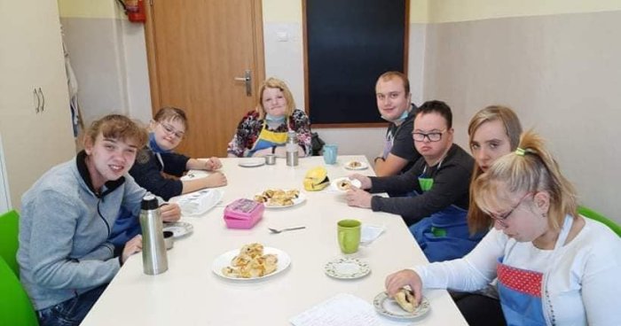 Uczniowie degustują placek z powidłami, wykonany w ramach zajęć kuchennych.