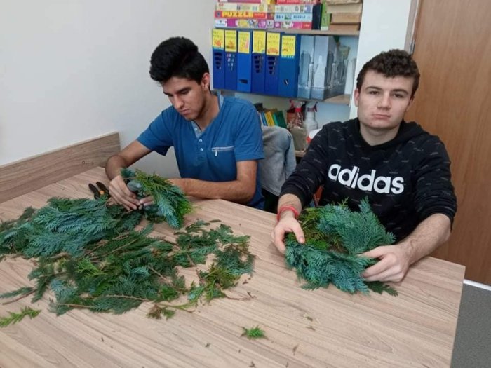 Uczniowie z zaangażowaniem wykonują wianki. 