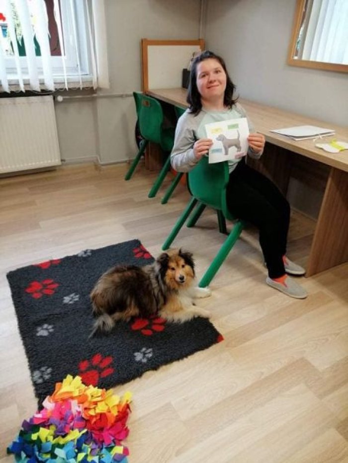 Uczennica prezentuje wraz z psem Kerrią poprawnie wykonane zadanie, polegające na dopasowaniu nazw części ciała do wizerunku psa.