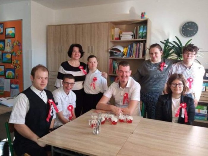 Uczniowie klasy 2 przysposabiającej do pracy w stroju galowym świętują 11 listopada przy słodkim deserze.
