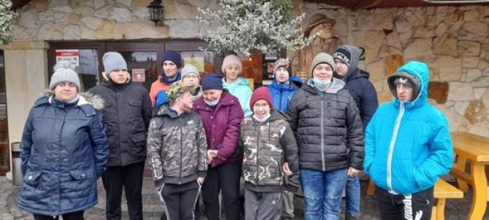 Uczniowie klasy przysposabiających pozują do zdjęcia przez Zajazdem Beskidy. 